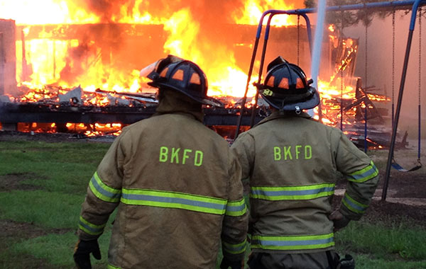 Photo of two firemen in front of fire